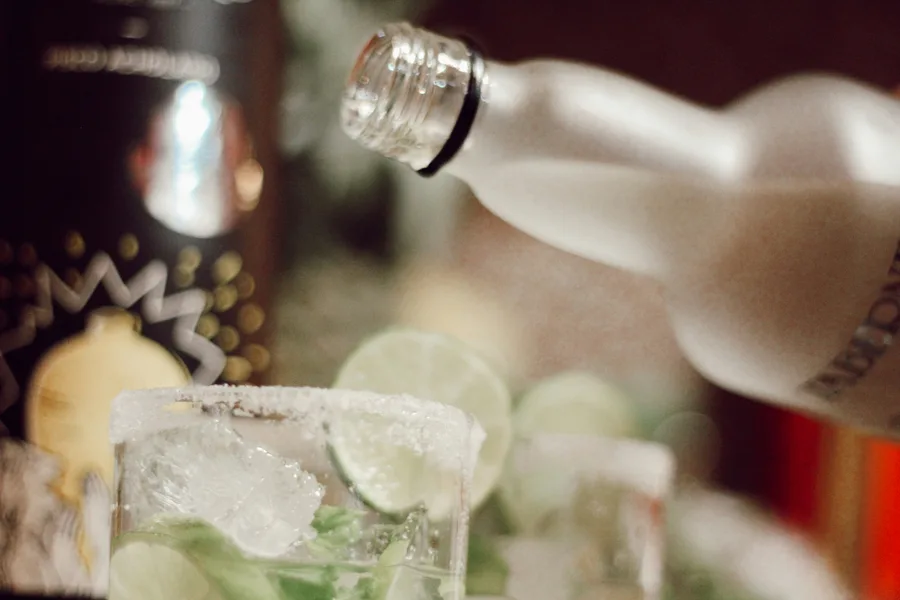 Cocktail being mixed with lime and ice