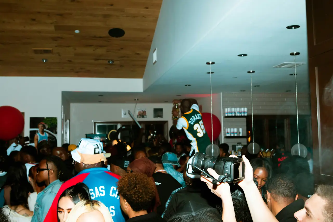 A packed, energetic house party with people celebrating